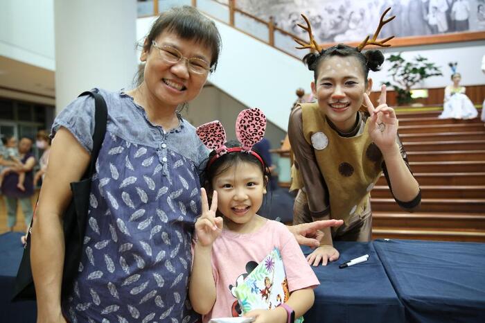 王女士帶著孫女來看兒童劇，繪本簽名後和邱毓蓉姊姊合照。